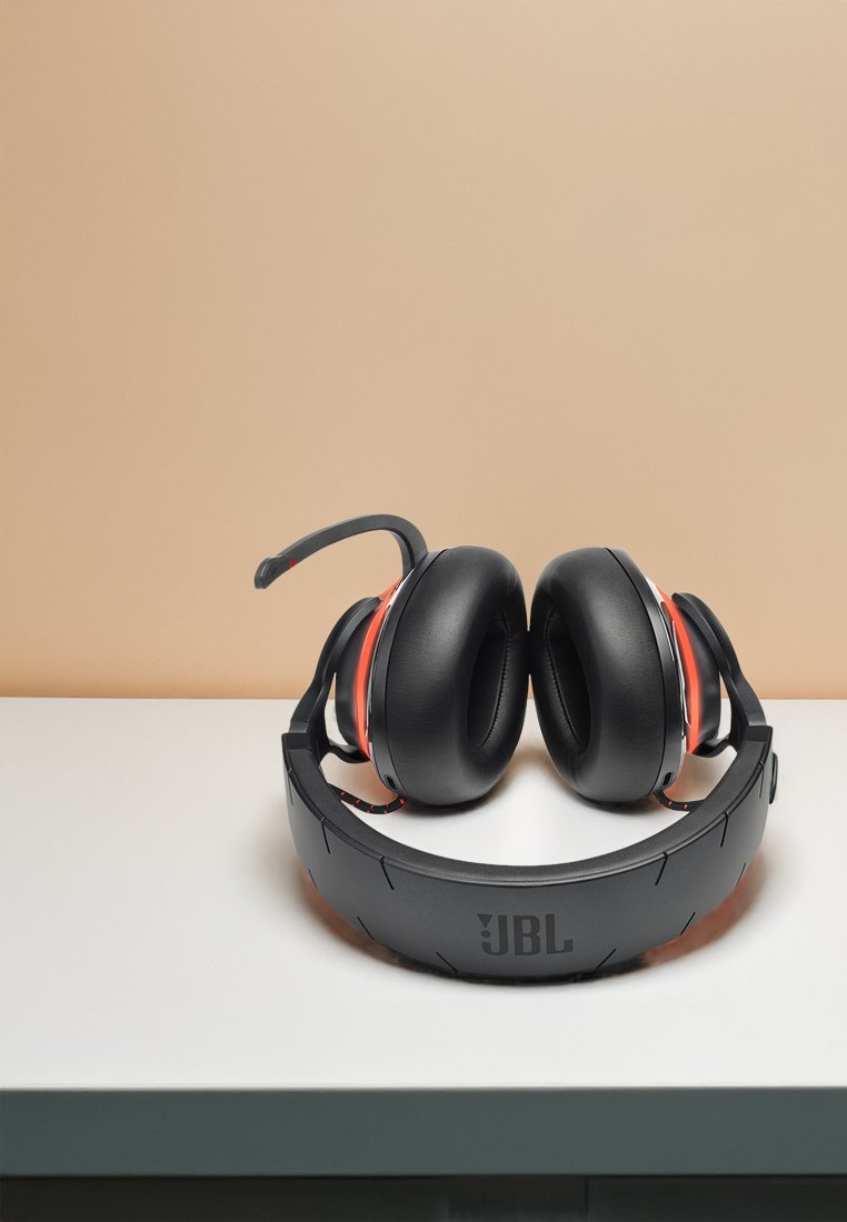 Cuffie over-ear nere con padiglioni imbottiti e archetto regolabile, con accenti rossi e il logo JBL sul copertura.
