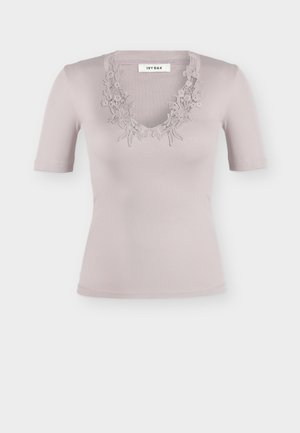 Haut côtelé mauve clair à manches courtes avec bordure en dentelle florale autour d'un décolleté en V, étiqueté « IVY OAK » au col.