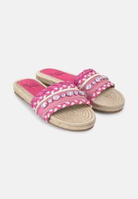 Sandalias de slide tejidas en color rosa con correas trenzadas y gemas decorativas transparentes, con suela de yute y forro interior estampado.