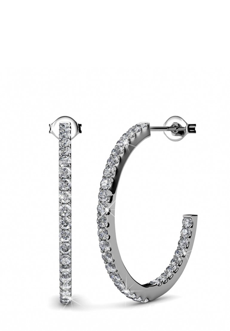 Orecchini a cerchio in metallo di tonalità silver, con una fila di falsi diamanti rotondi e trasparenti lungo il bordo esterno e una finitura lucida e raffinata.