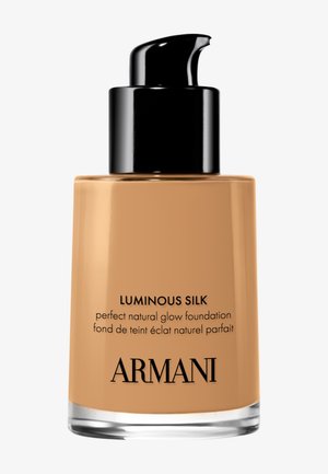 Armani Luminous Silk foundationflesje met zwarte pomp, beige vloeibare foundation binnenin, zwarte tekst op glazen container.