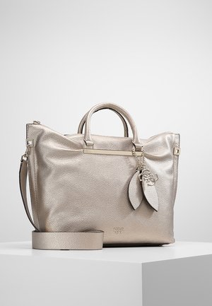 Metallic beige leather handbag with two handles, a detachable shoulder strap, and decorative leaf-shaped charms on a chain.