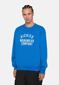 Sudadera azul de mezcla de algodón con un cuello redondo acanalado y puños. Presenta texto blanco que dice "DICKIES WORKWEAR COMPANY" en la parte frontal.