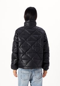 Czarna pikowana kurtka puchowa z wysokim kołnierzem, wykonana z materiału syntetycznego, z geometrycznym wzorem w diamenty na powierzchni.