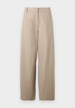Beige, bővített lábú pamutra készült nadrág. Jellemzője a sima elülső rész, két oldalsó zseb és sima textúra. Egyszerű, funkcionális dizájn.