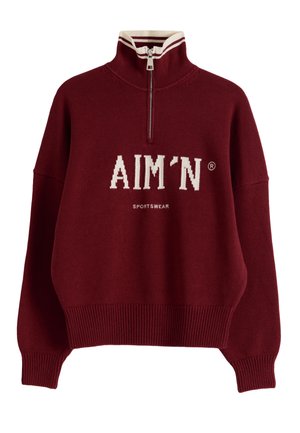 Suéter pulóver marrón con cremallera hasta la mitad, cuello alto con una franja blanca, puños y dobladillo acanalados, y logo blanco "AIM'N SPORTSWEAR" en el frente.