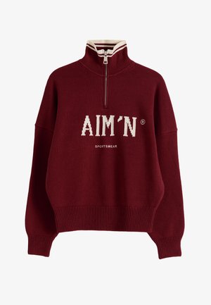 Bordowy sweter typu pulower z półzamek, wysokim kołnierzem z białym paskiem, ściągaczami na mankietach i dole oraz białym logo "AIM'N SPORTSWEAR" na przodzie.