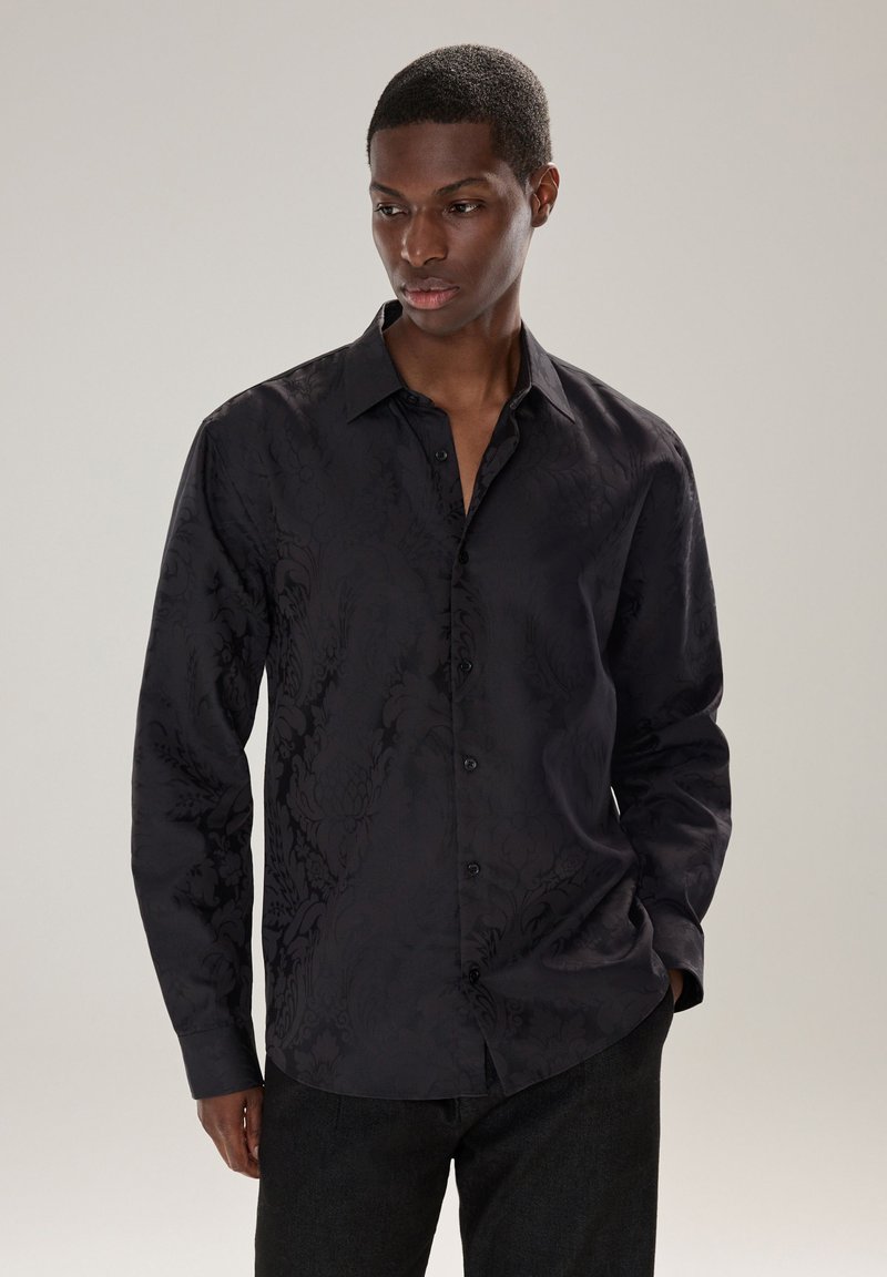 Camicia nera a maniche lunghe con tessuto floreale sottile, colletto con bottoni e bottoni frontali. Realizzata in tessuto liscio con vestibilità sartoriale.