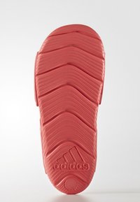 Suela de sandalia Adidas de color coral con un patrón zigzagueante texturizado y detalle del logo circular. El material parece flexible y duradero.