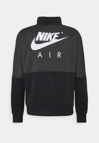 Nike svart sweatshirt med hög krage, prydd med stora vita "NIKE" och "AIR" logotyper, färgblockdesign samt ribbade muddar och nederkant.