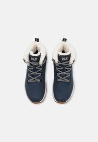 Scarponi da trekking blu navy con fodera in finta pelliccia bianca, lacci bianco e neri e suola in gomma beige. Logo sulla linguetta.