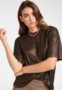 Metallisk brun kortærmet T-shirt med blød tekstur og afslappet pasform, der har en diskret glans og rund halsudskæring.