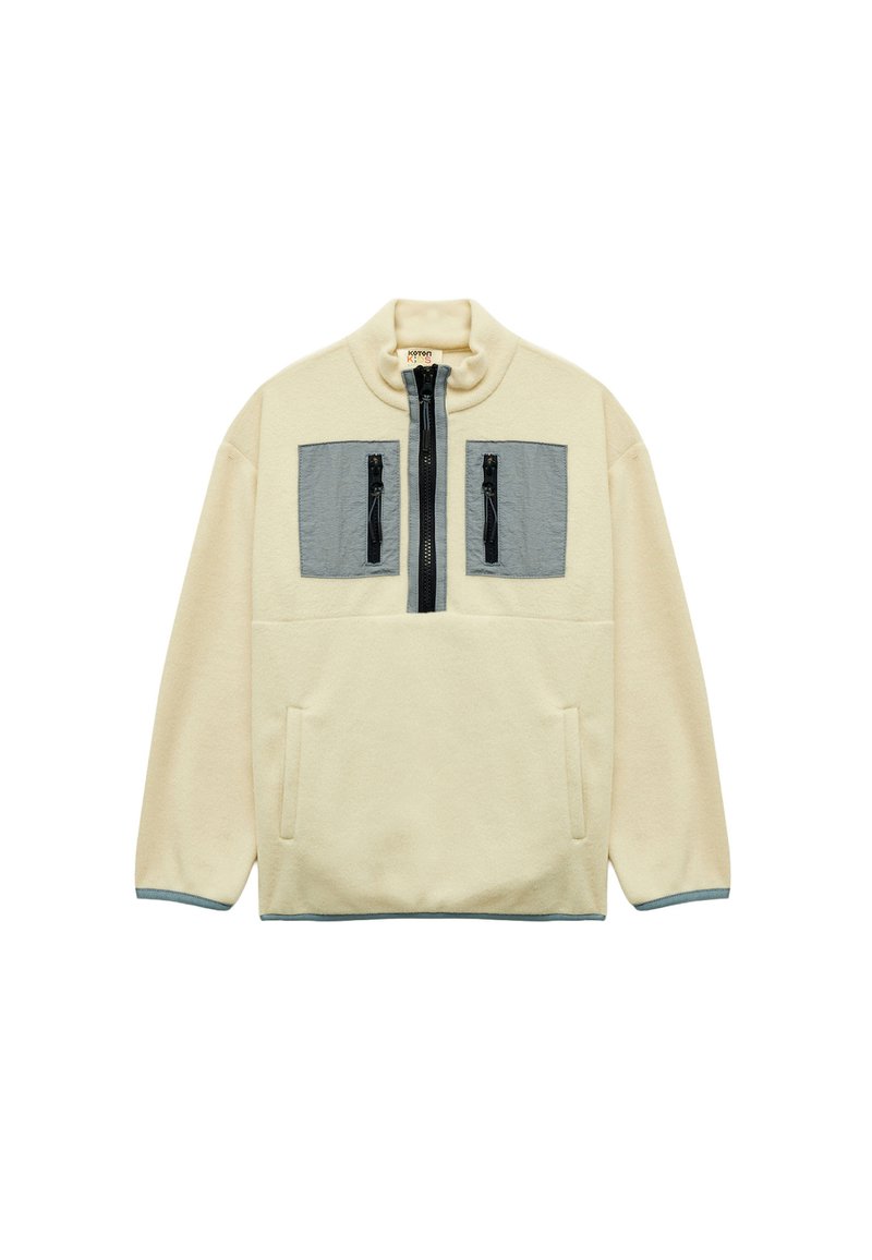 Fleece-Pullover in Creme mit grauen Brusttaschen. Verfügt über einen hohen Kragen, einen halben Reißverschluss vorne, seitliche Taschen und kontrastierende Bündchen.