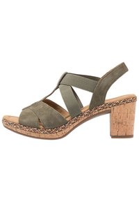 Vihreät mokka-sandaalit ristikkäisillä remmeillä ja joustavilla nauhoilla. Korkkipohjainen korko, jossa on monivärinen punos ympärillä.