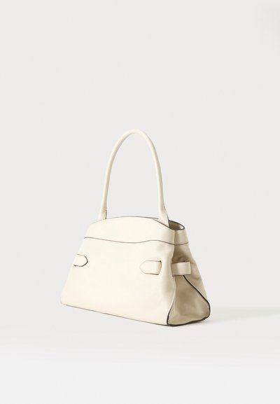 Sac à main en cuir couleur crème avec une poignée incurvée unique et des détails discrets de couture, placé sur un fond clair uni.