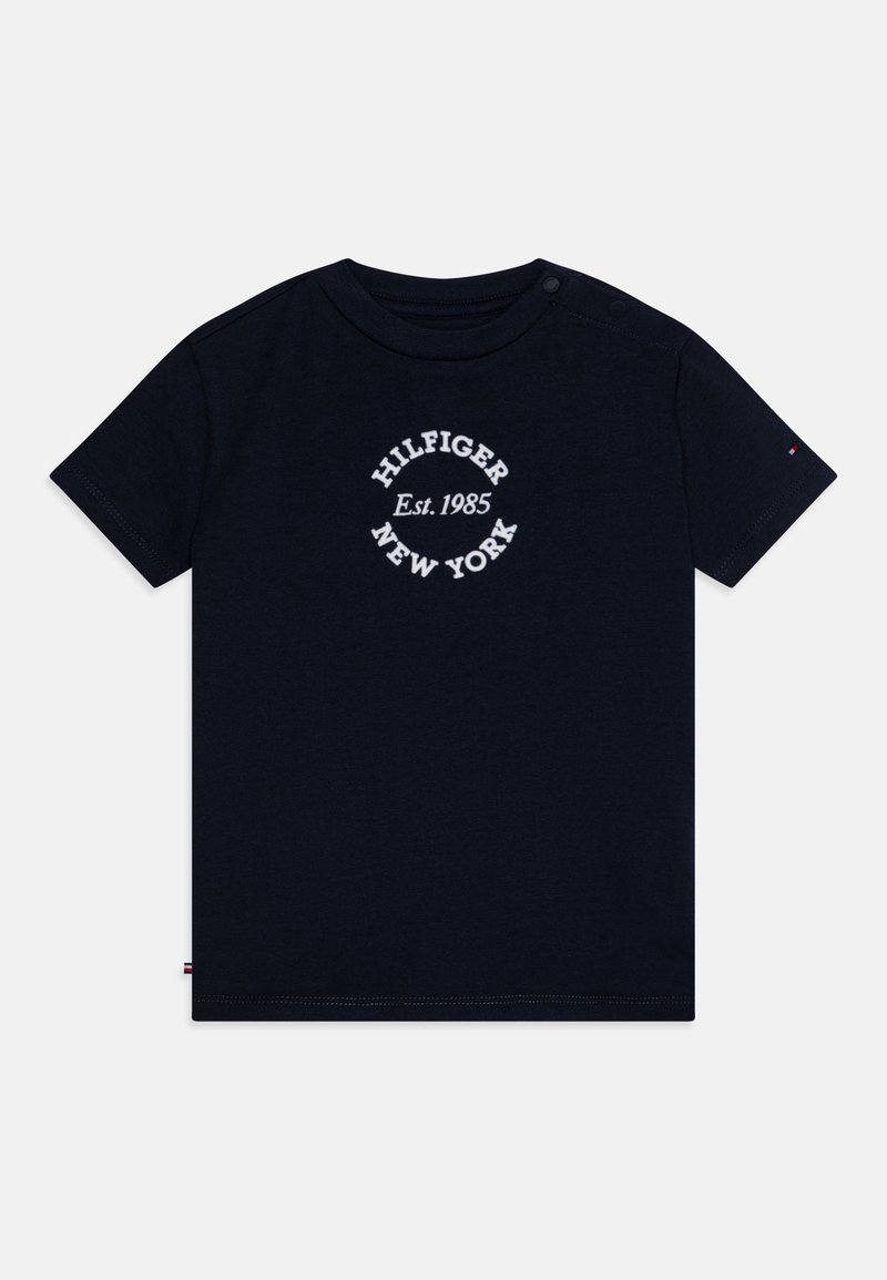 Σκούρο μπλέ βαμβακερό t-shirt με κοντά μανίκια, στρογγυλή λαιμόκοψη και ένα λευκό κυκλικό λογότυπο που γράφει "HILFIGER Est. 1985 NEW YORK."