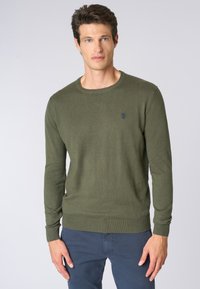 Maglione a maglia verde oliva con maniche lunghe e scollatura a girocollo. Presenta polsini e orlo a coste, con un piccolo logo ricamato sul petto.