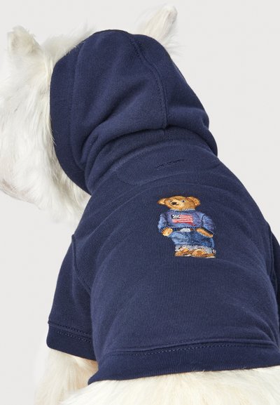Sweat-shirt à capuche pour chien en bleu marine, avec un ours brodé portant une tenue bleue et un drapeau américain, texture douce, manches courtes.