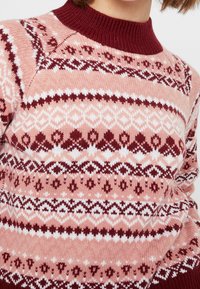 Maglione rosa con un colletto a coste color bordeaux, complessi motivi geometrici bianchi e bordeaux, e una texture lavorata a maglia.
