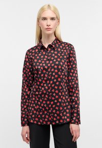 Langærmet sort skjorte med et blomsterprint i rød, med en knap-ned krave og frontklap, lavet af glat stof.