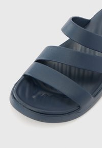 Sandalo scivolo blu navy con tre larghe cinghie; realizzato in materiale liscio. Soletta testurizzata per il comfort, design della punta arrotondata.