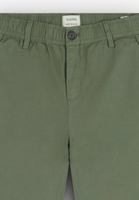 Pantalones cortos verdes oliva de algodón con cintura elástica, cierre de botón en la parte delantera y detalles de costura sutiles. Sin patrones o acentos visibles.