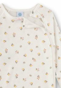 Baby-Strampler aus weichem, cremefarbenem Stoff mit floralem Muster in Pink und Gelb sowie Kronen, vorne mit Reißverschluss und Druckknöpfen am Hals.