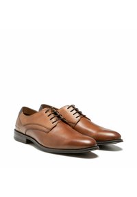 Bruine leren dresschoenen met een gladde afwerking, ronde neus en een vetersluiting met vijf oogjes; voorzien van subtiele gebogen stiksels en een zwarte hak.