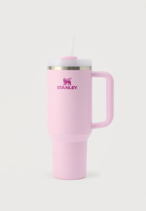 Vaso de viaje alto, aislado, de color rosa con asa, tapa blanca, pajita y logo de Stanley sobre un fondo liso y claro.