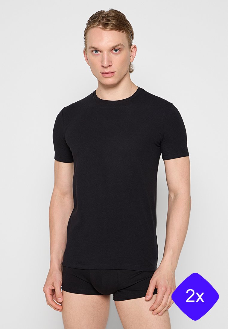 Camiseta negra de manga corta hecha de suave algodón, con cuello redondo, corte regular y textura suave. Se usa con bragas negras.