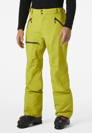 Pantalones de esquí amarillos brillantes hechos de un tejido impermeable con bolsillos con cremallera, cinturilla ajustable y un corte relajado; compatibles con botas de esquí.