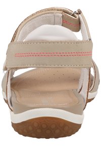 Sandali beige con strap regolabili, cuciture rosa, suola interna morbida e suola esterna in gomma con grip strutturato. Design con apertura sul retro.