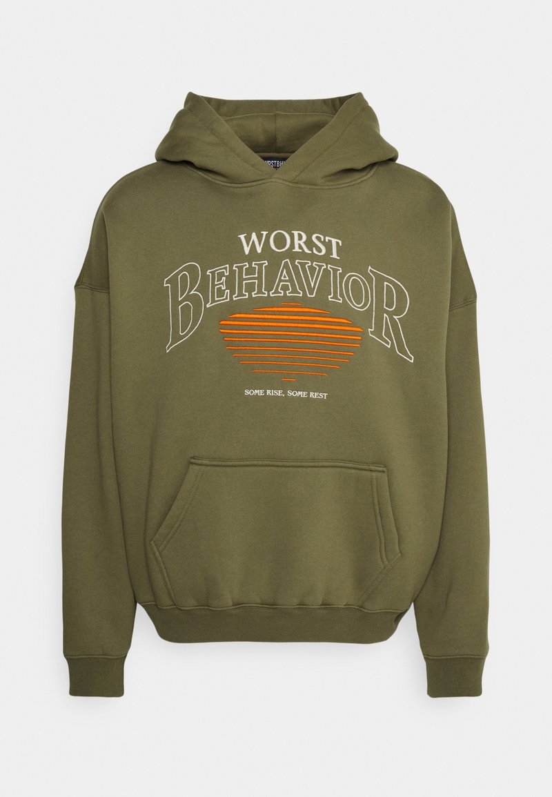 Sudadera verde oliva con cordón, bolsillo frontal y texto impreso en blanco y naranja: “PEOR COMPORTAMIENTO” con líneas horizontales.