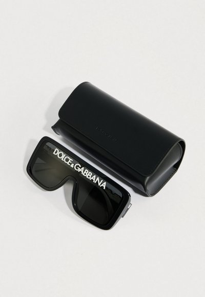 Mustad üle suuruses päikeseprillid tumedate läätsedega, millel esiküljel valgete tähtedega "DOLCE & GABBANA". Komplektis mustast nahast karp.