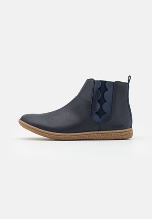 Bottes chelsea en cuir navy avec des accents élastiques festonnés et une semelle texturée marron. Équipées d'une languette pour un enfilage facile. Fini lisse.