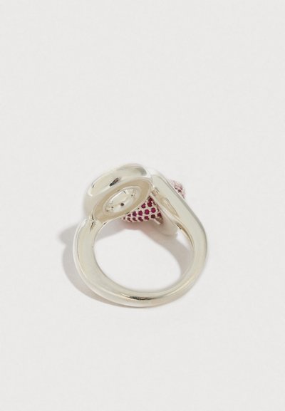 Bague en argent avec un design lisse et torsadé et un accent rose texturé. Présente une finition polie et une forme arrondie.