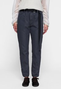 Pantaloni grigi scuri realizzati in tessuto leggero, con una vestibilità rilassata, vita elastica e una cintura nera. Inclusi tasche laterali e orli con risvolto.