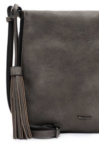 Szara torebka crossbody z fakturowanej skóry, z długim akcentem w postaci frędzla i regulowanym paskiem. Charakteryzuje się minimalistycznym designem oraz subtelnym detalem logo.