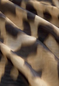 Tessuto a rete con stampa leopardata, base beige e macchie marrone scuro, caratterizzato da una consistenza fine, traspirante e una caduta morbida.