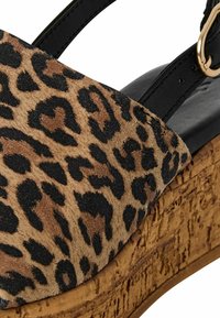 Infradito in suede con stampa leopardata, zeppa con suola testurizzata in sughero, cinturini neri e accento in metallo dorato.