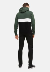 Sudadera con capucha con bloques de color verde, blanco y negro. Hecha de tela suave, con puños acanalados y un ajuste relajado.