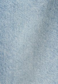 Tessuto di denim azzurro chiaro con una fine lavorazione a filo, caratterizzato da sottili variazioni di colore e texture, che mostrano un aspetto classico e uniforme.