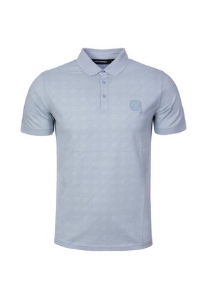 Světlomodré polo tričko z měkké tkaniny, s jemným geometrickým vzorem a malým vyšívaným logem na hrudi. Přední část se zapínáním na dva knoflíky.