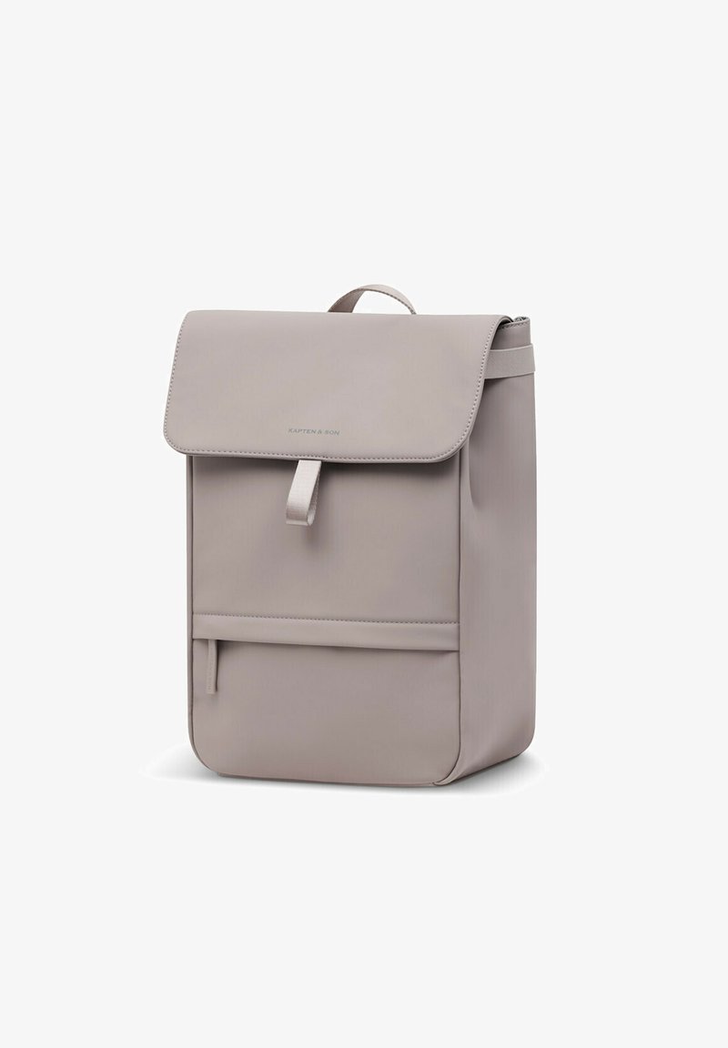Sac à dos rectangulaire gris clair minimaliste avec rabat supérieur, poche zippée à l'avant et petite poignée de transport sur fond blanc.