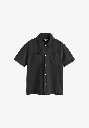 Fekete rövid ujjú, gombos ing két első mellzsebbel és szabványos gallérral, fehér háttéren bemutatva.