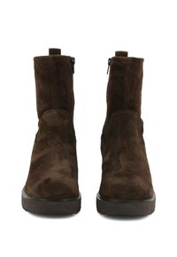Stivaletti alla caviglia in suede marrone con una superficie liscia, suola piatta in gomma e cerniere laterali per un facile utilizzo. Design minimalista con punta arrotondata.