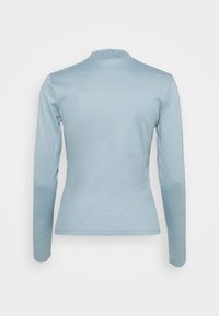 Maglietta a maniche lunghe di colore azzurro chiaro con un design aderente, scollatura arricciata testurizzata e tessuto liscio; senza motivi visibili o accessori.