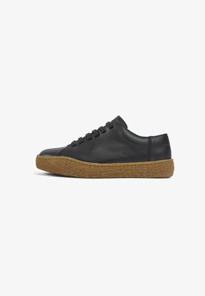Zwarte leren sneaker met een ronde neus, een getextureerde bruine rubberen zool en zes metalen oogjes voor veters. Gladde afwerking met minimale stiksels.