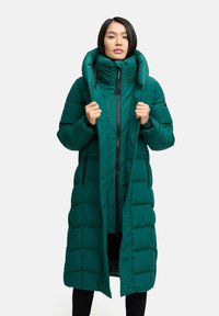 Lungo cappotto verde imbottito con colletto alto, caratterizzato da motivi a motivo orizzontale e una cerniera frontale. Il cappotto ha due tasche laterali.