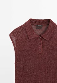 Polo sans manches bordeaux en maille avec trois boutons et un col côtelé sur fond blanc.